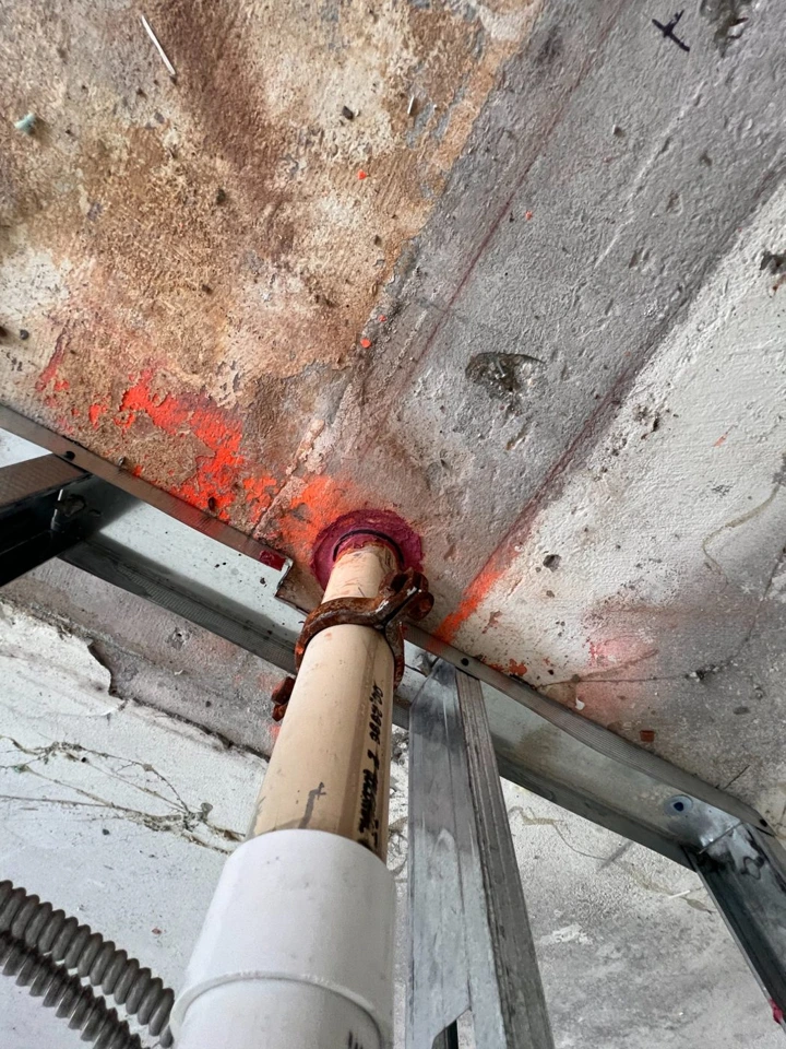 Close-up photograph of a firestopped pipe penetration
